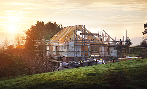 construction site of a house surrounded by scaffolding during sunset showcasing building materials 1 construction project